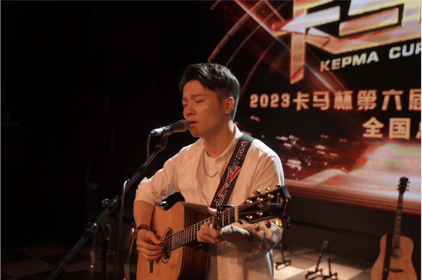 Male contestant singing and playing guitar